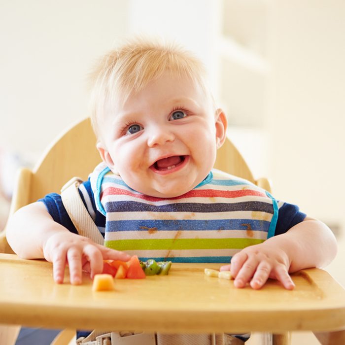 Baby Boy Eating Fruit In High Chair; Shutterstock ID 177222725