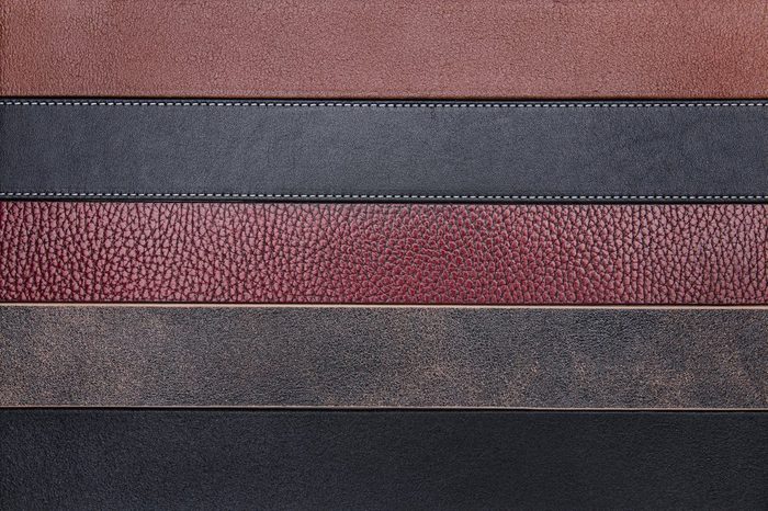 Dark natural leather belts close-up texture background
