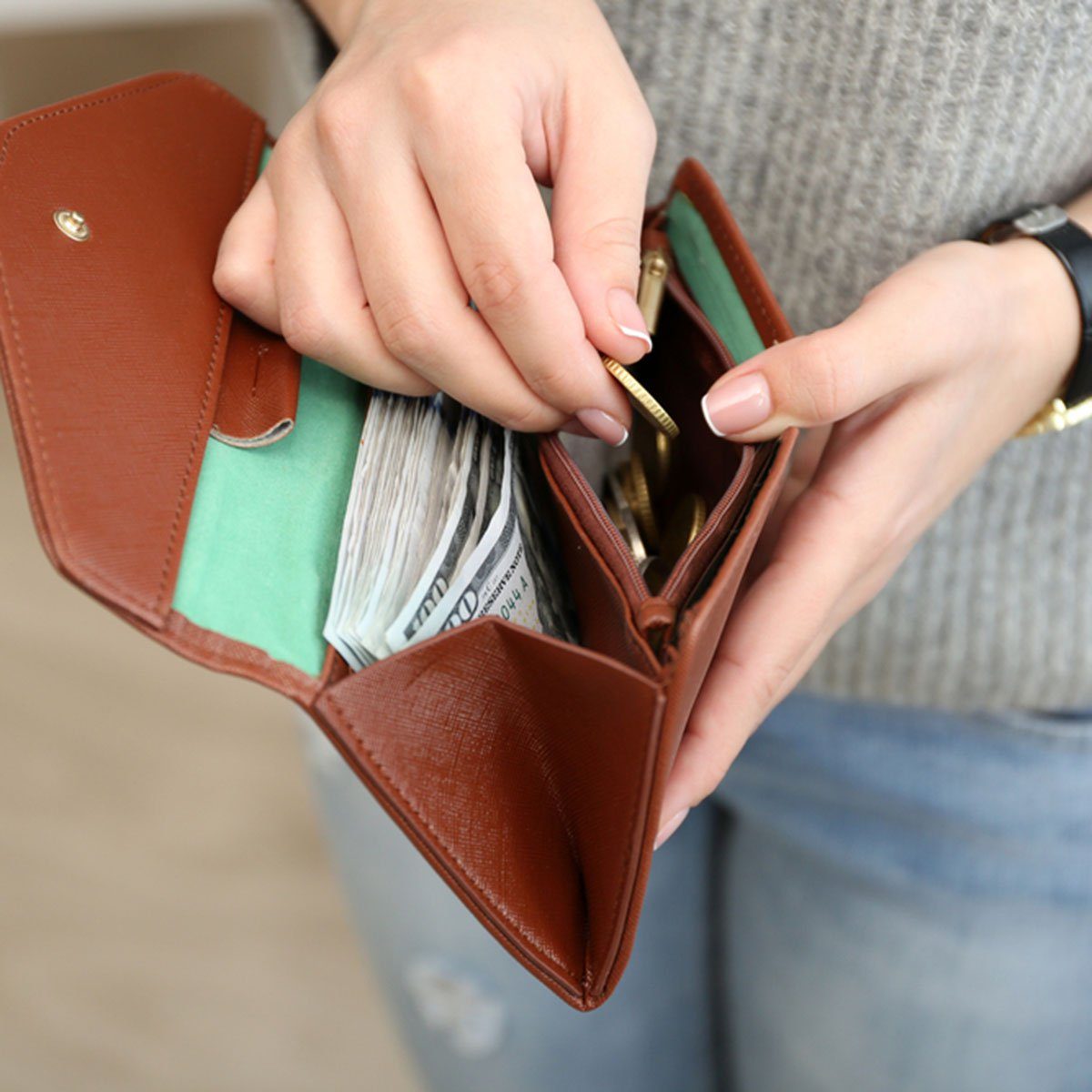 Girl with brown wallet full of money; Shutterstock ID 394142461