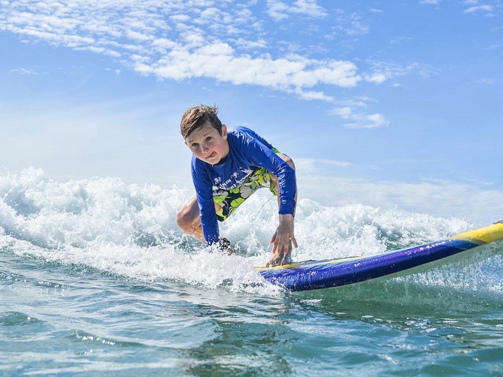 Teenage boy surfing at Los Cerritos Beach in Todos Santos