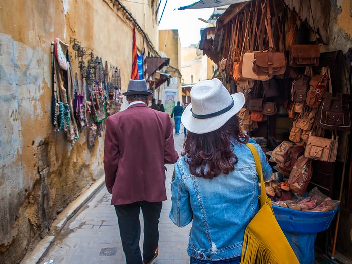 Tips for booking vacation online - travellers wandering souks of Marrakech
