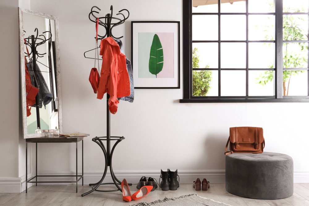 Modern hallway interior with clothes on hanger stand and mirror