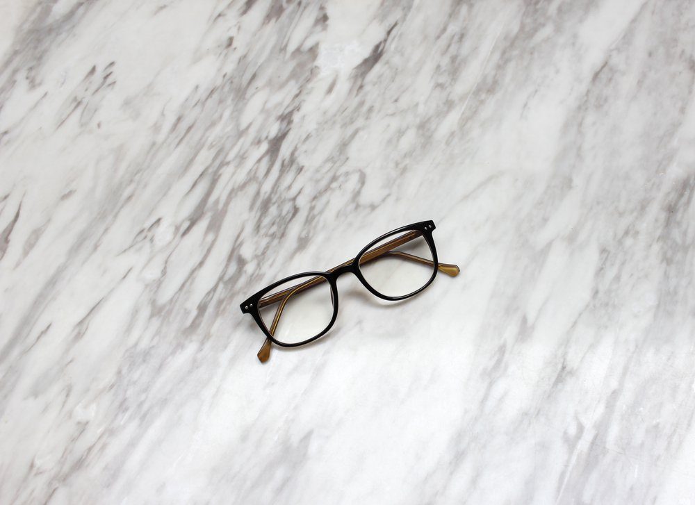 Eyeglasses on black and white marble table texture