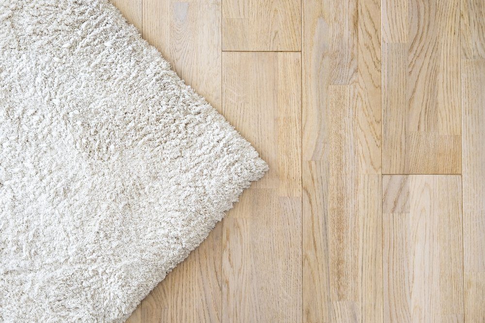 Laminate parquete floor. Light wooden texture. Beige soft carpet. Warm interior design
