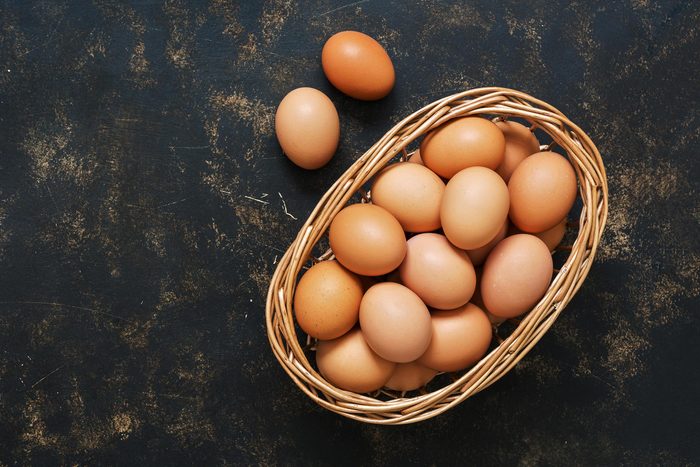 Foods everyone over 50 should be eating - Brown eggs in a basket on an old dark surface. Top view, space for text