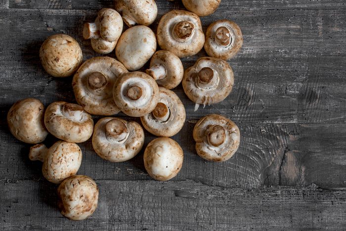 Foods everyone over 50 should be eating - Flat lay mushrooms champignon on dark wood desk top view layout