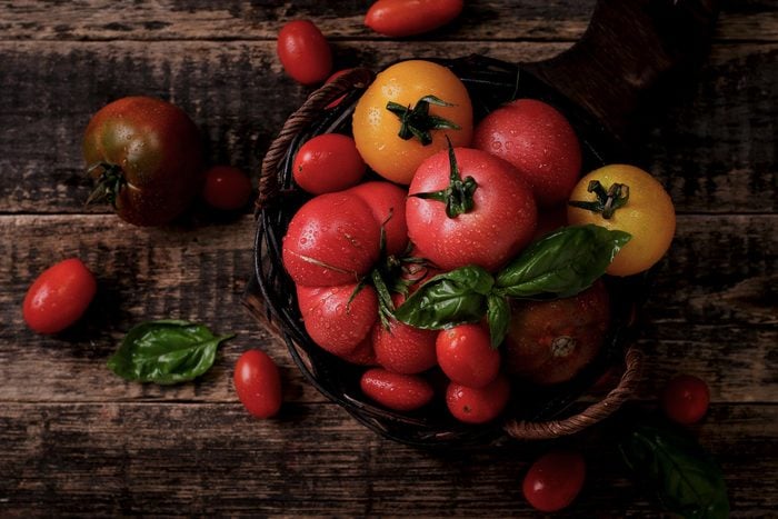Foods everyone over 50 should be eating - Colourful tomatoes, red , yellow , orange , green on vintage wooden background