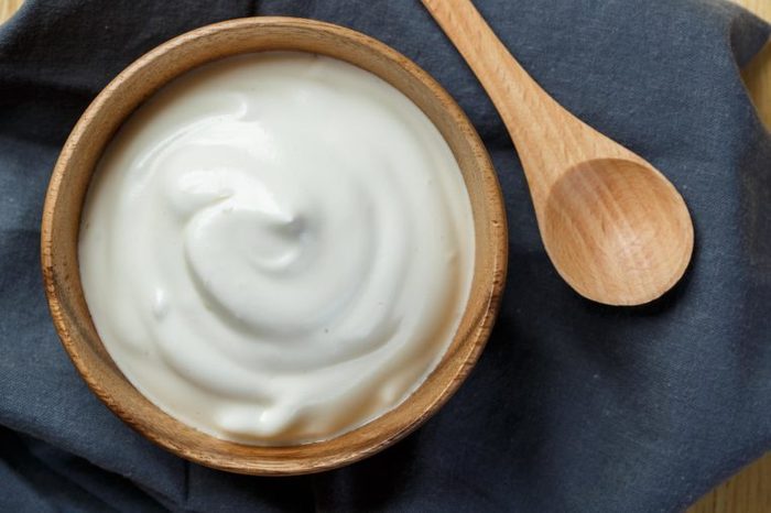 Homemade yogurt or sour cream in a wooden bowl