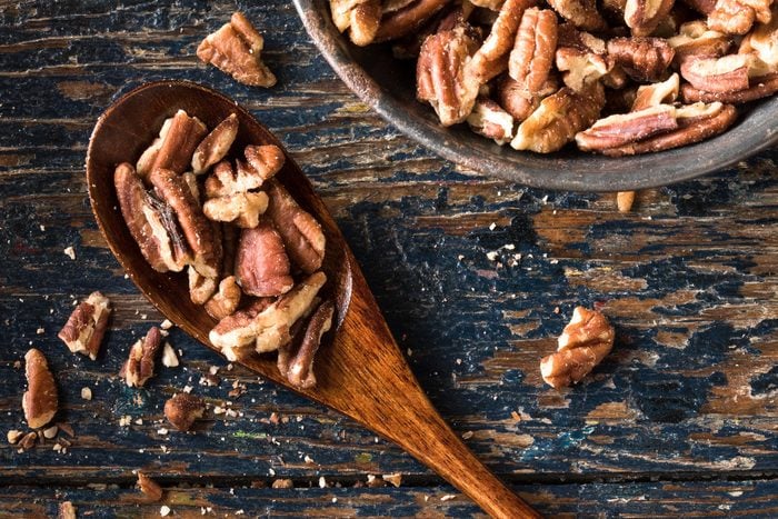 Foods everyone over 50 should be eating - Chopped pecans on a wood spoon