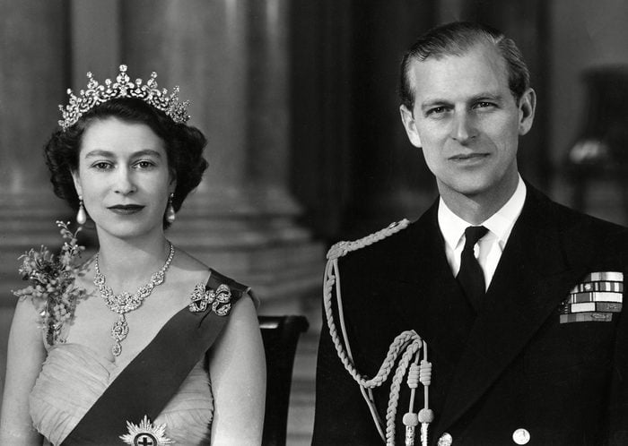 Historical Collection 172 Queen Elizabeth Ii and Prince Philip Duke of Edinburgh Pictured Together in the Grand Entrance in Buckingham Palace in 1954 the Queen is Wearing A Yellow Tulle Evening Gown Decorated with Sprays of Mimosa and Gold Pailette Embroidery and is Wearing the Blue Ribbon and Star of the Garter Her Necklace Was A Wedding Present From the Nizam of Hyderabad; the Tiara Also A Wedding Present From Queen Mary the Bow Brooch and Drop Earrings Are Set with Diamonds the Duke is Wearing the Uniform of the Admiral of the Fleet 1954