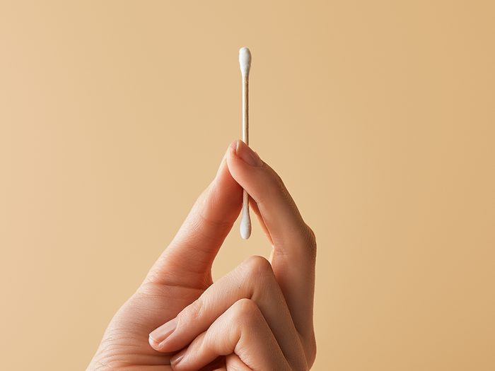 Stop using cotton swabs to clean ears - hand holding cotton swab