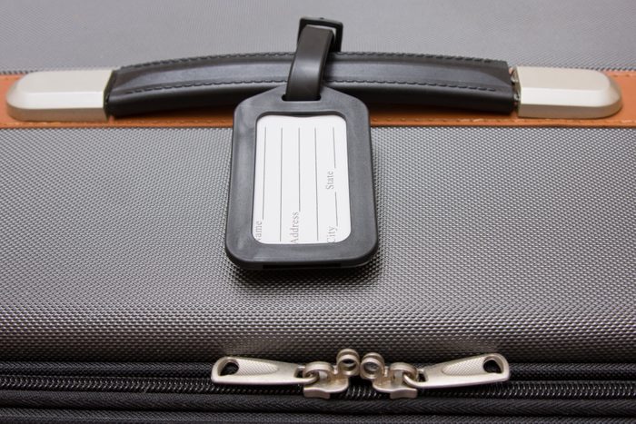 A black luggage tag on a handle on a bag