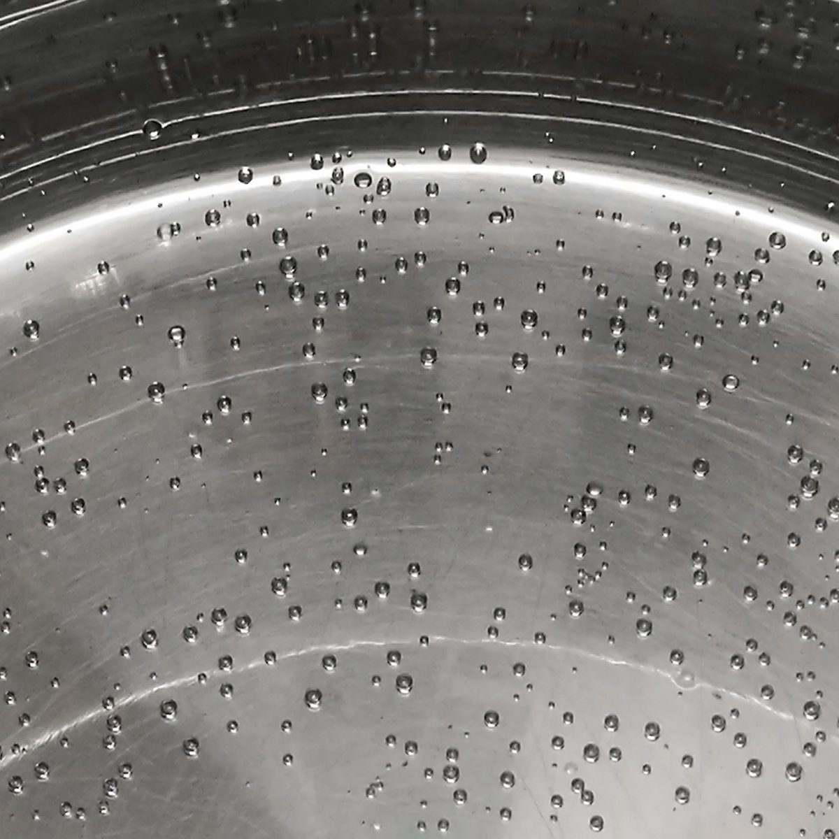 Drops of water on pan / saucepan stainless steel surface.