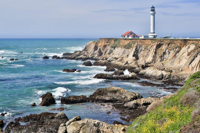 Point Arena Lighthouse and rocky coastline of the Pacific Ocean. Mendocino County, California, USA.