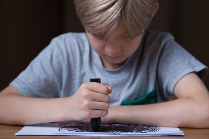 Young boy is drawing during his therapy