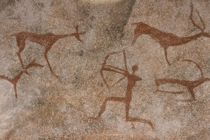 Figure animals and hunter on the stone wall of the cave paint ocher ancient prehistoric Neanderthal. prehistoric animal, stone age hunting for deer