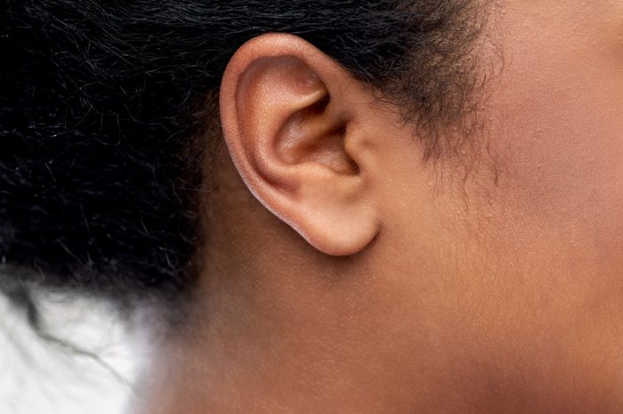 health, people and hearing concept - close up of young african american woman ear