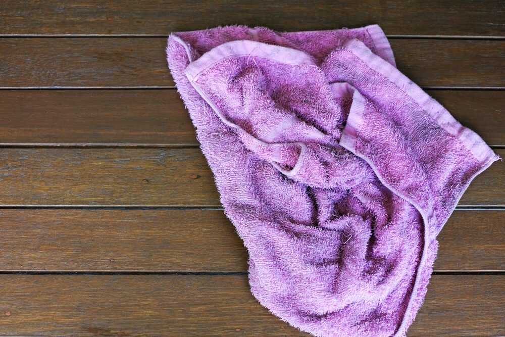 Items You Don’t Wash Enough - purple rag isolate on wooden background