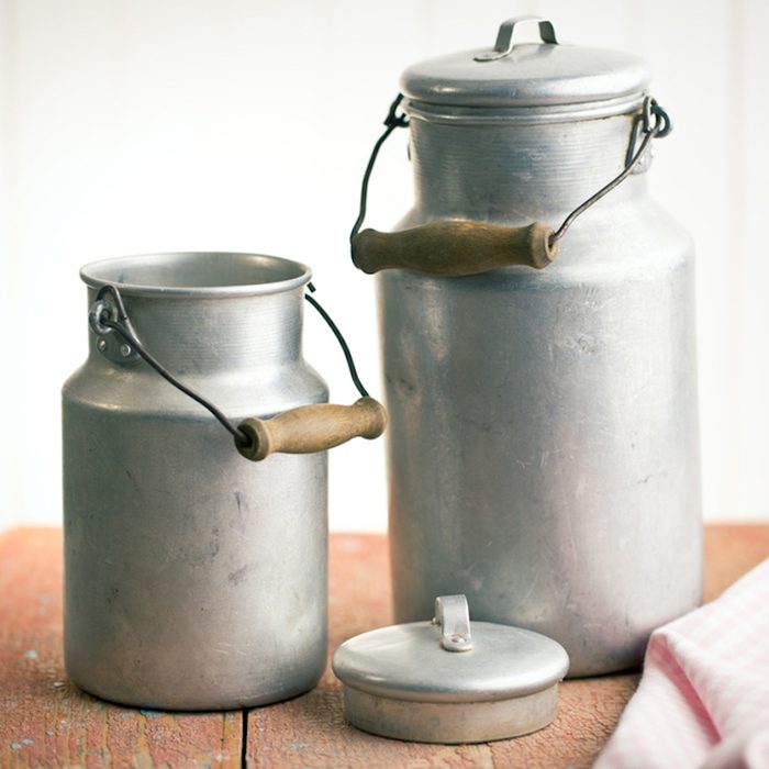 vintage milk cans on old wooden table; Shutterstock ID 181187597