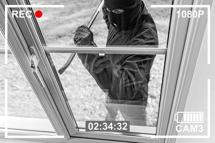 Ways burglars break in - burglar opening window with crowbar