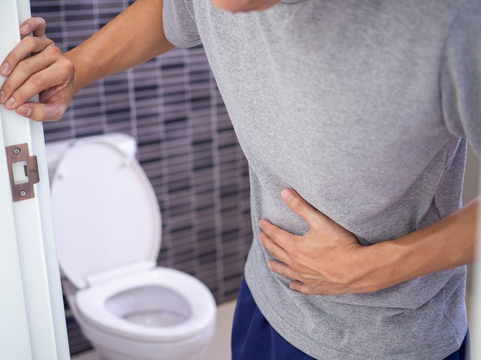 What your poop says about your health - man leaving bathroom just pooped