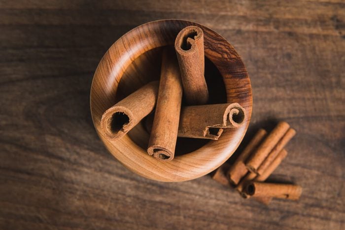cinnamon in a wooden bowl of olive wood - Stock Image