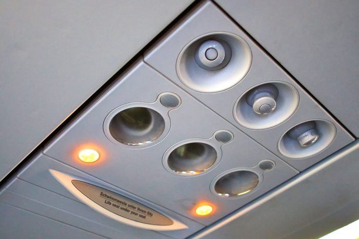 Passenger plane cabin overhead panelwith lights turned on