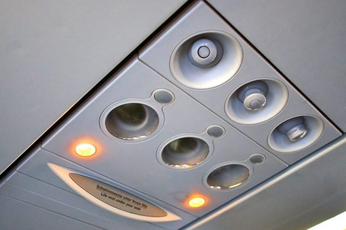 Passenger plane cabin overhead panelwith lights turned on