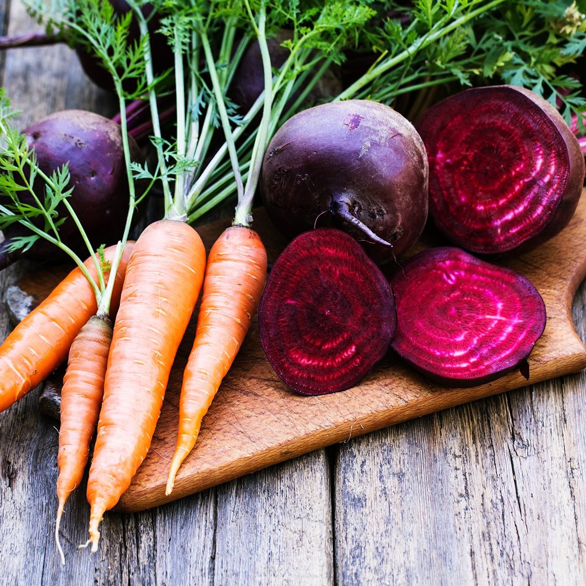 Fresh beet and carrots on wooden background