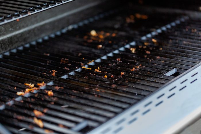 Dirty cast iron cooking grates on outdoor gas grill.