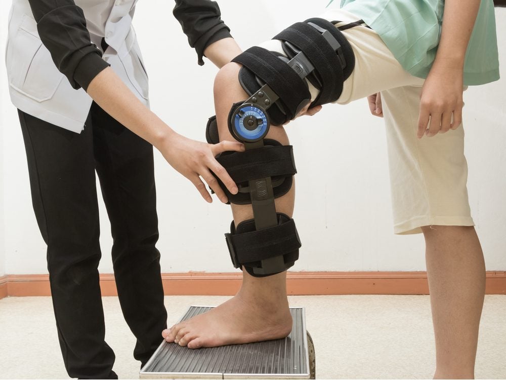 Therapist fitting a knee brace to a patient