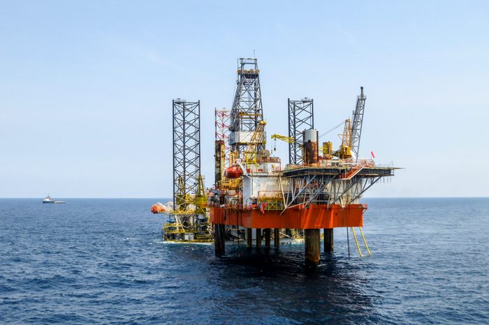 Drilling rig is installed side by side to production oil platform in offshore oil and gas field.