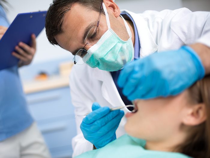 Oral cancer symptoms - dentist examining patient