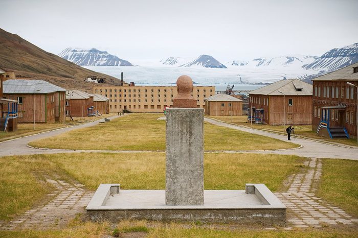 PYRAMIDEN, NORWAY - SEPTEMBER 03, 2011: View to abandoned Russian arctic settlement with the bust of Lenin in the foreground in Pyramiden, Norway.