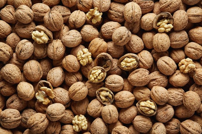 Walnuts with and without shells (filling the picture). Background of fresh walnuts.