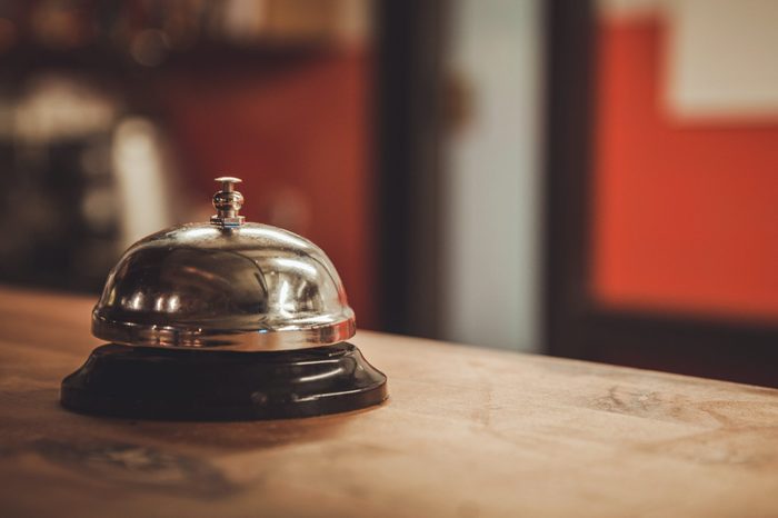 Restaurant service bell on the table vintage with bokeh, evening light background.Business concept Serve today hotel, kitchen or bar visit.