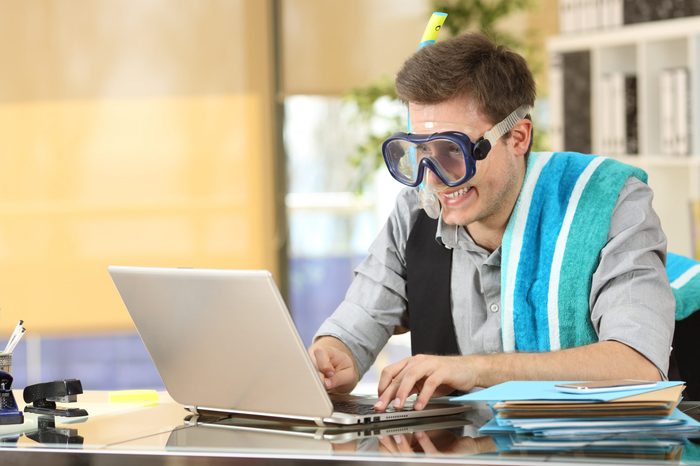 Businessman working on line or searching travel destinations with goggles needing vacations at office