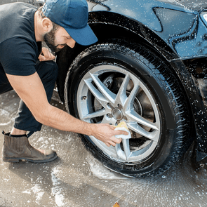 Car washing tips from the pros - man cleaning car tires