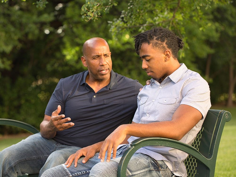 How to talk about money with family - father and son on a park bench