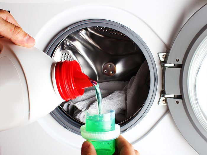 Pouring laundry detergent into washer