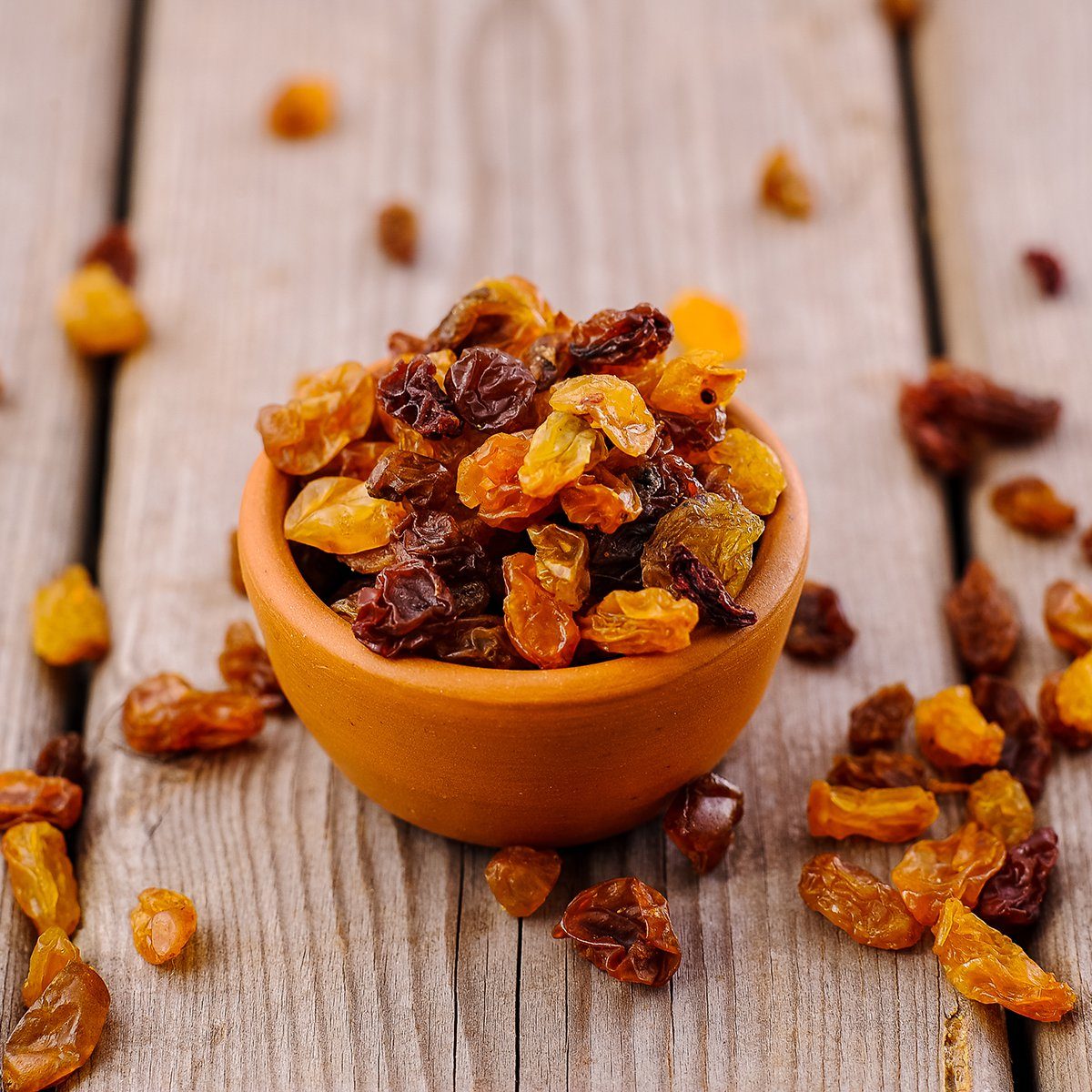 bowl of raisins. raisins on a wooden background.