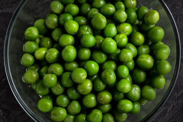 Buttered Peas. Green Peas on dark background.