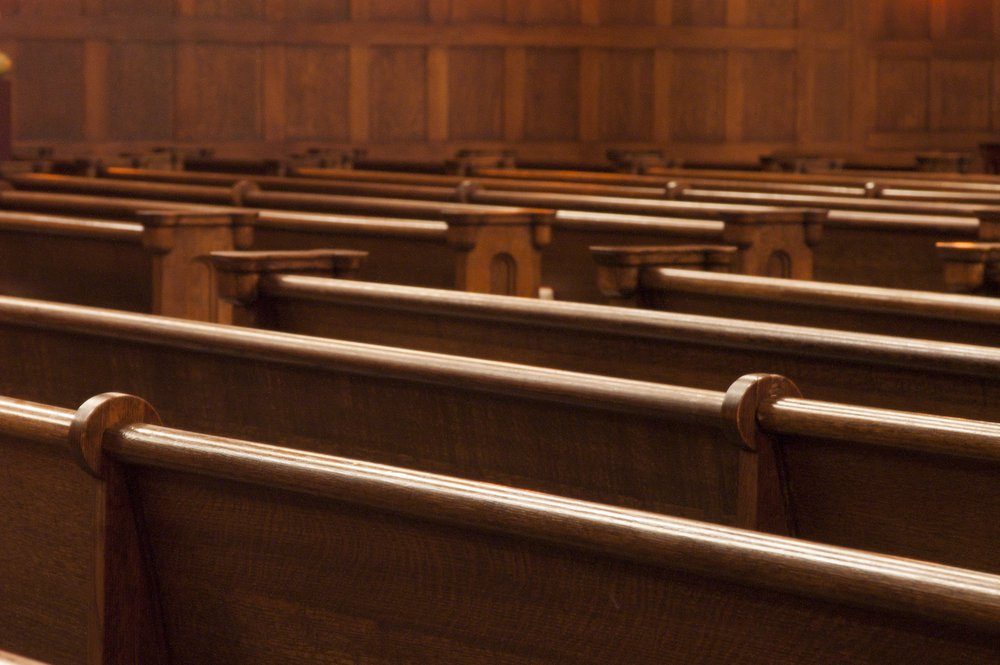 Rows of wodden pews in a church