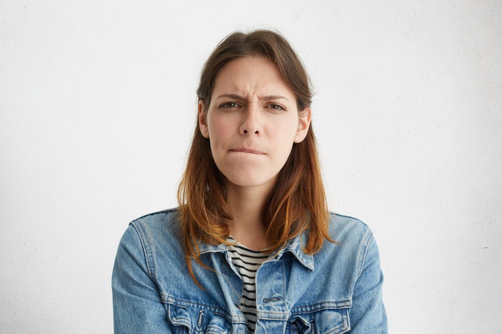 Anxious or worried woman with pursed lips and furrowed brow