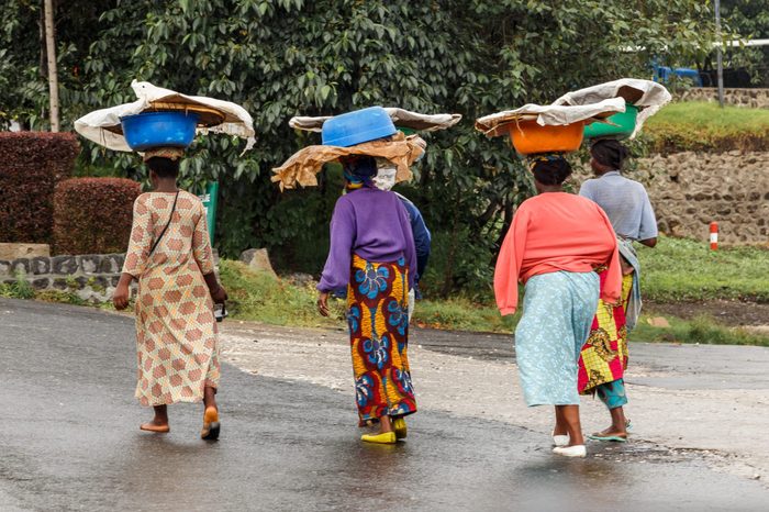 Group of Rwandan women in colorful traditionals clothes wearing washbowls on their heads, Kigali, Rwanda