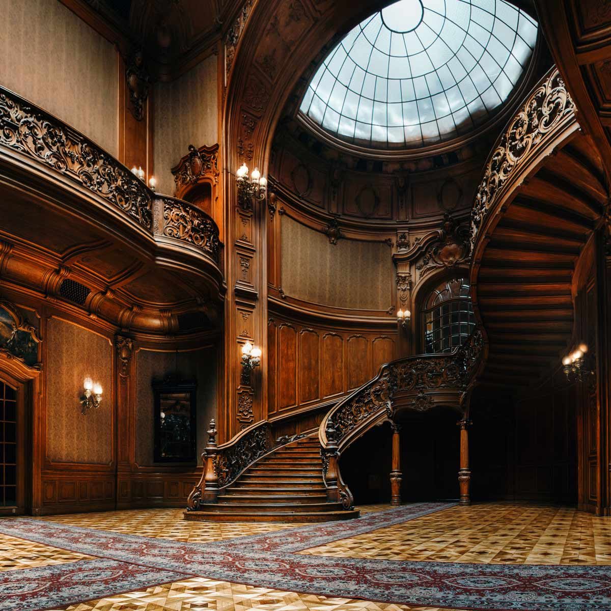 Interior of the magnificent House of Scientists mansion with ornate grand wooden staircase in the great hall.