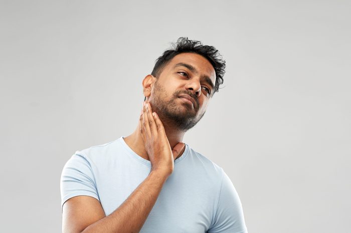 health problem and people concept - unhealthy indian man suffering from sore glands or tonsils over grey background