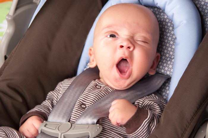 Portrait of a yawning baby Boy In Safety Seat