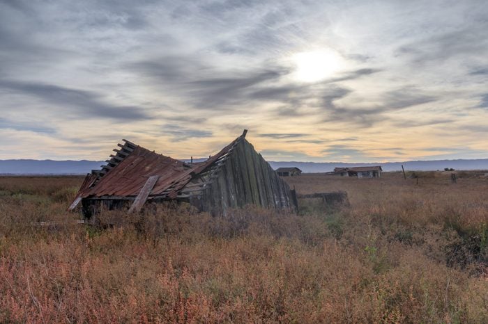 Sunset over abandoned house at Drawbridge, the last remaining ghost town in San Francisco Bay Area. Don Edwards San Francisco Bay National Wildlife Refuge, Fremont, Alameda County, California, USA.