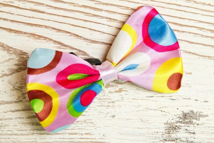 Funny, colorful bow tie on white wood